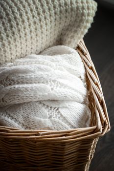 Knitwear, fabric textures and rustic lifestyle concept - Knitted winter clothes in a basket