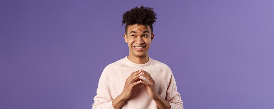 Close-up portrait of creative young hispanic guy steeple fingers while making-up great plan or joke, look away daydreaming, scheming something, have idea, stand purple background.