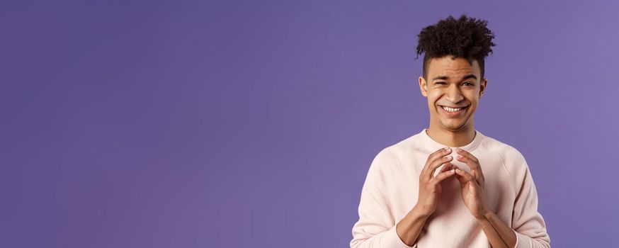 Portrait of creative young smart man with dreads, steeple fingers near chest and smirk devious, have perfect plan, scheming something for april fools day, standing purple background sly.