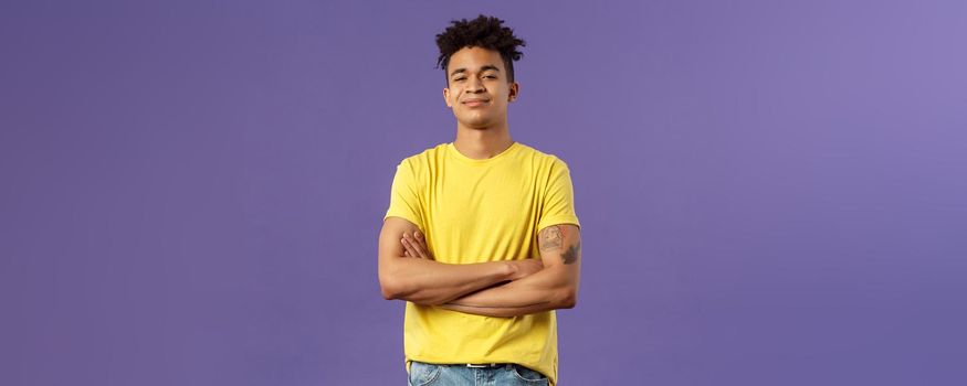 Close-up portrait of arrogant, proud and boastful young smart guy cross hands over chest in confident, self-assured pose, smirk and look mighty, feel like he knows everything, purple background.