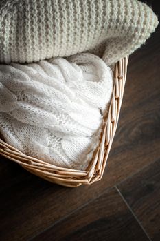 Knitwear, fabric textures and rustic lifestyle concept - Knitted winter clothes in a basket