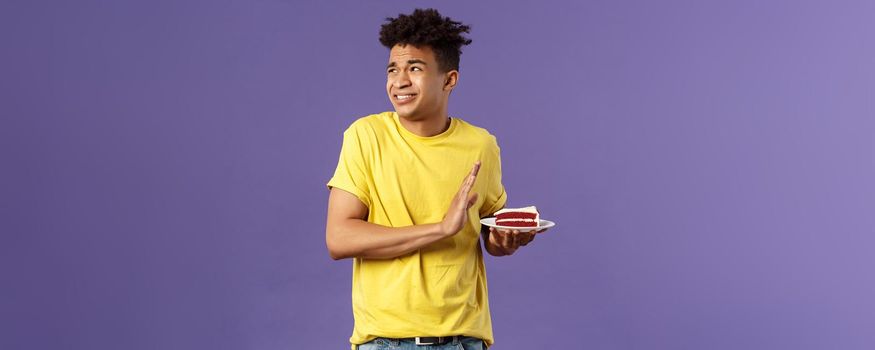 Celebration, party and holidays concept. Oh gosh its disgusting. Portrait of reluctant and displeased young man turn away from awful bad taste cake, show refusal, rejection or stop sign.