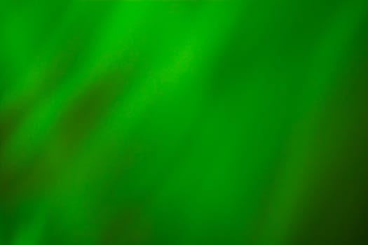 Abstract wavy background, silky green fabric with soft blur and highlights. Backdrop