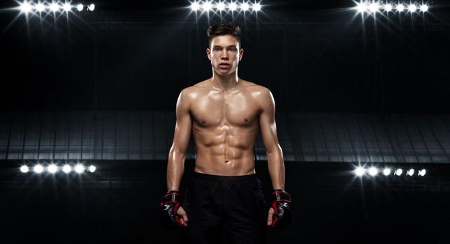 Street fighter fighting in boxing cage. Background with lights and smoke. Action shot with copy space.