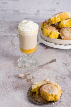 pumpkin cinnabons and latte for dessert, holiday table with pastries, home sweet home, autumn menu. High quality photo