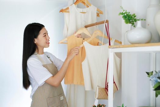 Young asian businessowner checking clothes in small business.Businessman checking inventory in stock room. Store house inspection.