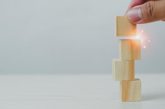 Hand wood block stacking on a table. Business growth Choose a business concept for development and success. Copy space