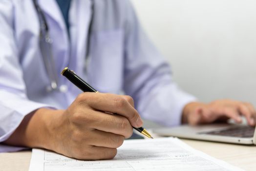 Doctor signs the patient paperwork at the desk.health care and insurance concept.