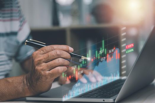 Finance and business investment concept. Stock and crypto investment funds.Businessman analyzing or trading Forex graphs of financial data candlestick chart.