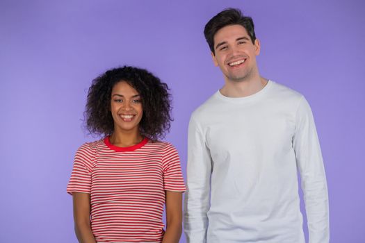Portrait of young couple on purple studio background. African american woman and white man. Interracial race love concept. High quality photo
