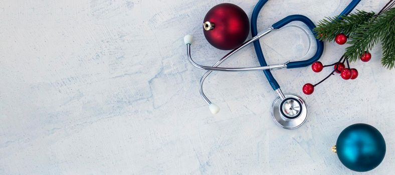 banner with Stethoscope with branches of Christmas tree and Christmas balls on a white concrete table. Concept Merry Christmas and Happy New year or Healthy New Year. Copy space. Flat lay