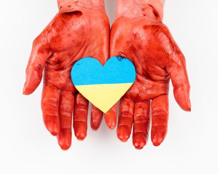 Woman with hands covered in blood holding a heart with the flag of ukraine on a white background
