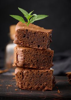 Baked pieces of chocolate brownie pie on black table, delicious dessert