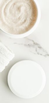 Scrub and exfoliating cream products on a marble, flatlay - skincare and body care, luxury spa and clean cosmetic concept. Health and beauty of your skin