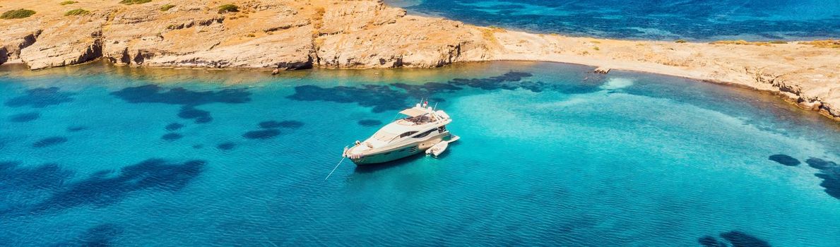 View from above, stunning aerial view of a bay with boat, luxury yacht sailing on a turquoise, clear water. download photo