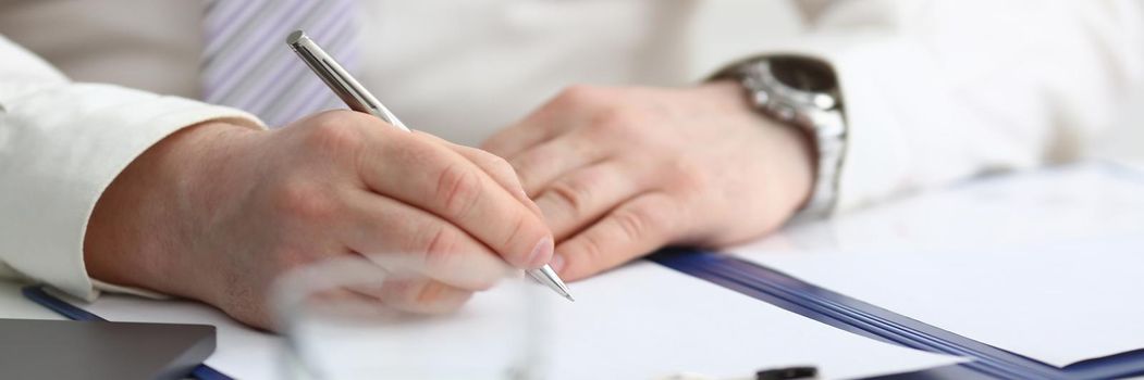 Man hand holds pen and fills out schedule of working day. Financial investment expert consultation concept
