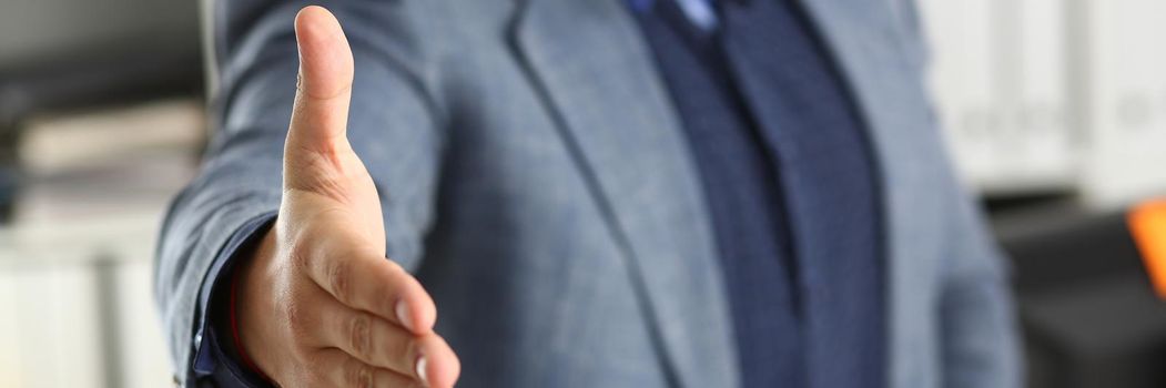 Businessman working in the office, reaching out hand forward for handshake. Business arrangement concept