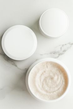 Scrub and exfoliating cream products on a marble, flatlay - skincare and body care, luxury spa and clean cosmetic concept. Health and beauty of your skin