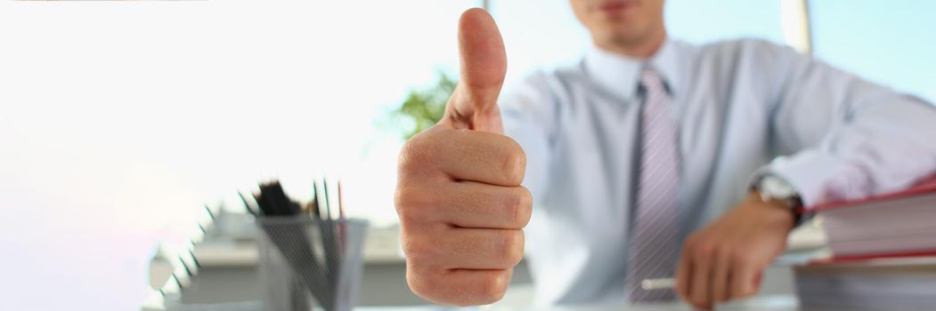 Businessman makes thumbs up gesture. Consulting and business advice concept