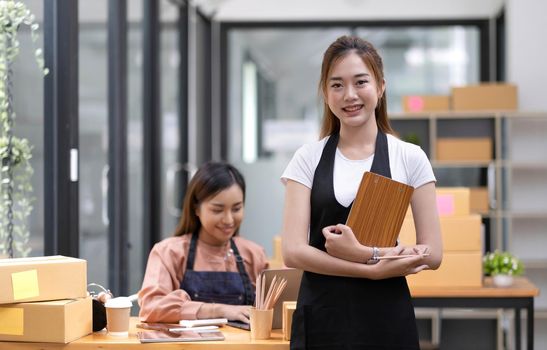 Portrait of Asian young woman SME working with a box at home the workplace.start-up small business owner, small business entrepreneur SME or freelance business online and delivery concept..