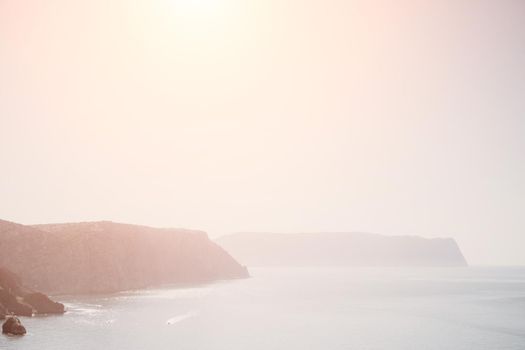 Abstract nature summer or spring ocean sea background. Small waves on water surface in motion blur with bokeh lights from sunrise.