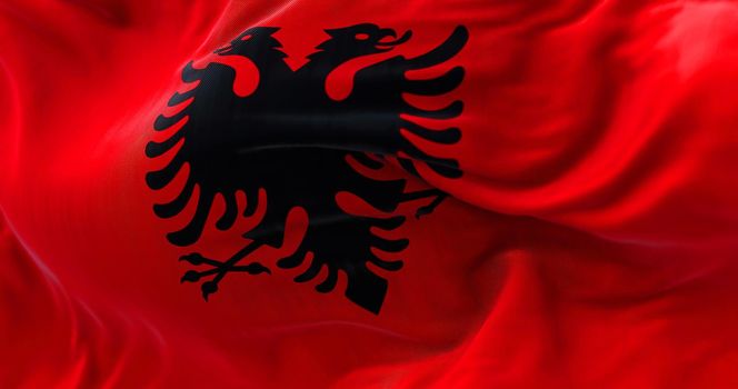 Close-up view of the Albanian national flag waving in the wind. Albania is a country in Southeastern Europe. Fabric textured background. Selective focus