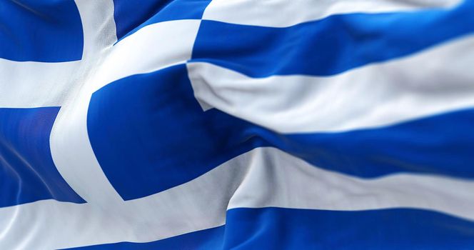 Close-up view of the greek national flag waving in the wind. Greece is a country at the crossroads of Central and Southeast Europe. Fabric textured background. Selective focus