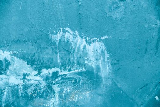 Textured blue plaster background with scratches and stains.