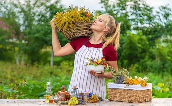 Woman with medicinal herbs and tinctures. Selective focus. Nature.