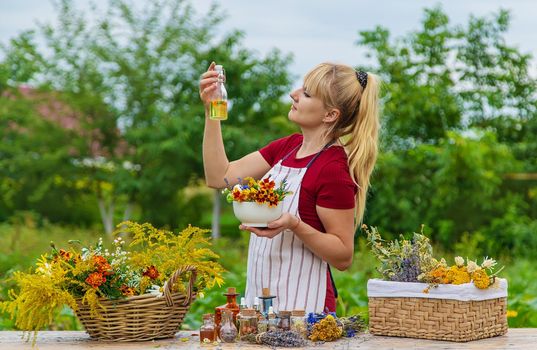 Woman with medicinal herbs and tinctures. Selective focus. Nature.