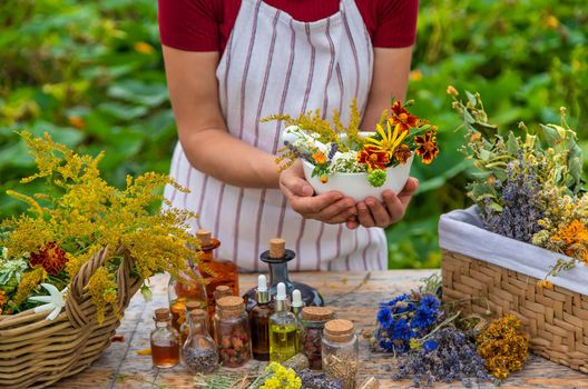 Woman with medicinal herbs and tinctures. Selective focus. Nature.