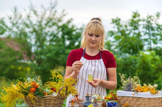 Woman with medicinal herbs and tinctures. Selective focus. Nature.