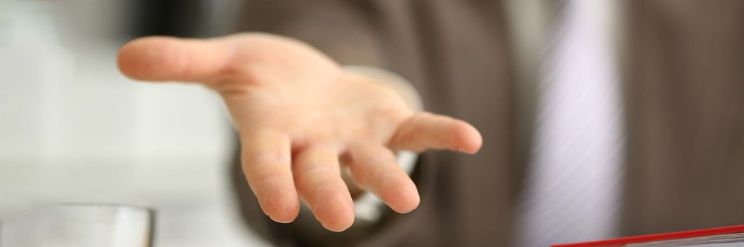 Man in suit extends open hand forward. Friendly open gesture concept