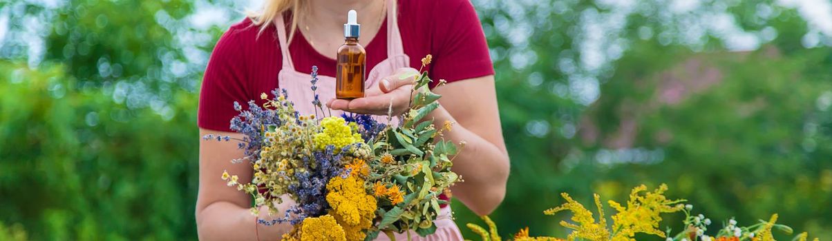 Woman with medicinal herbs and tinctures. Selective focus. Nature.