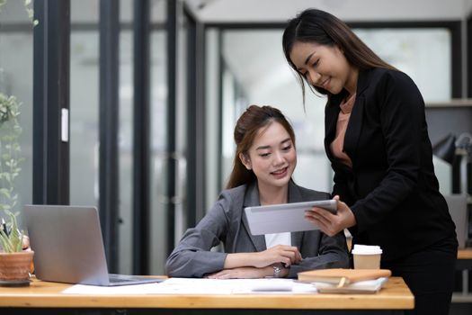 Two asian business woman work together to get the job done at the office..