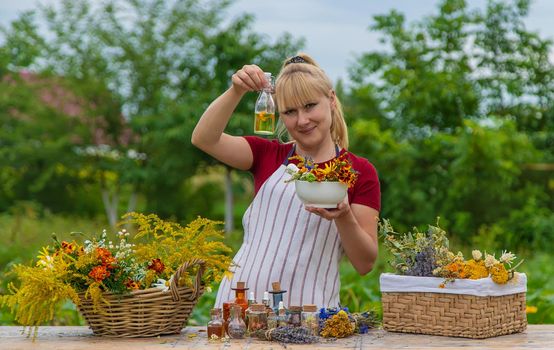 Woman with medicinal herbs and tinctures. Selective focus. Nature.