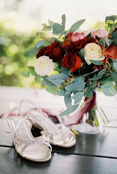 White wedding sandals stand on the table next to the wedding bouquet. High quality photo