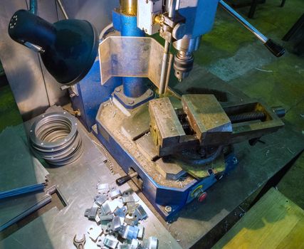 Drilling locksmith workplace with old dirty vertical drilling machine.