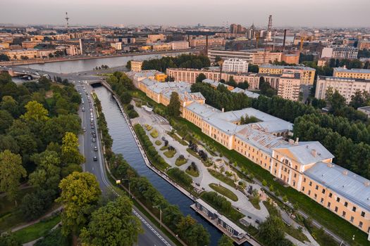 Aerial view of the public park of the Karpovka River Embankment in St. Petersburg at sunset, Russia, recreation areas, benches and amphitheater, botanical garden opposite the park. High quality photo
