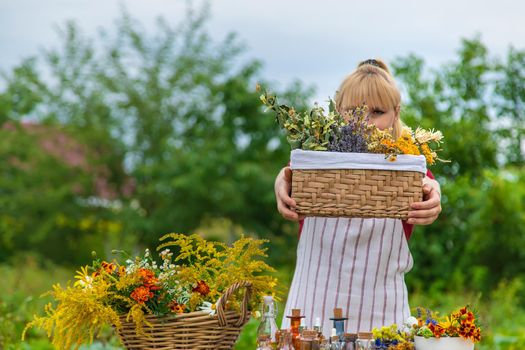 Woman with medicinal herbs and tinctures. Selective focus. Nature.