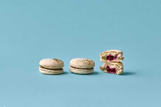 White macarons cake with colorful powder, top view, flat lay, sweet macaroon on blue background. Minimal concepts macaroons pattern above, food background