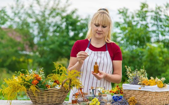 Woman with medicinal herbs and tinctures. Selective focus. Nature.