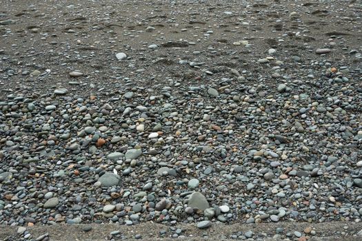 Pebbles on the shore close-up. Close-up of rounded and polished beach rocks.