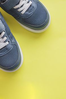 Blue children's sports shoes on a turquoise, mint background. The concept of using sport shoes by children