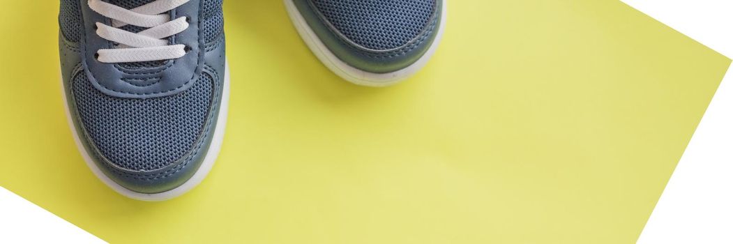 Blue children's sports shoes on a turquoise, mint background. The concept of using sport shoes by children