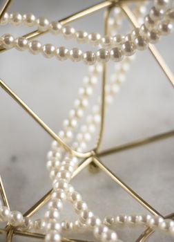 Pearl necklace on golden marble, ethical jewellery - luxury background, jewelry as a gift concept. Pearls are girl's best friends