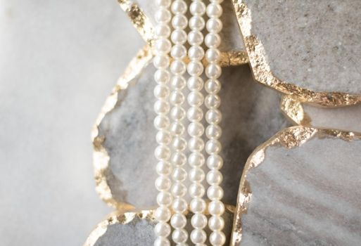 Pearl necklace on golden marble, ethical jewellery - luxury background, jewelry as a gift concept. Pearls are girl's best friends