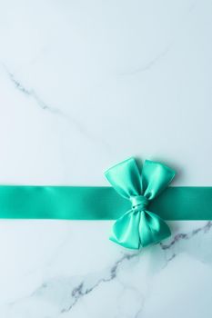 Holiday design, greeting card and vintage gift concept - Green silk ribbon on marble background, top view