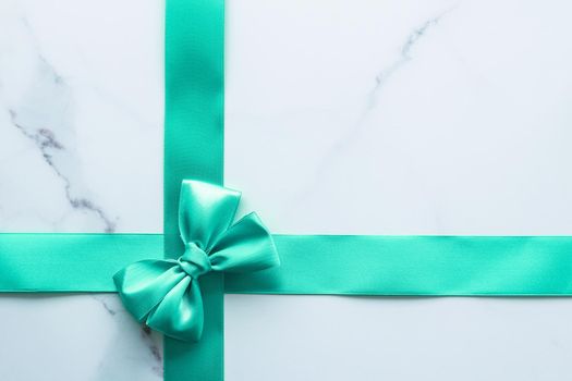 Holiday design, greeting card and vintage gift concept - Green silk ribbon on marble background, top view