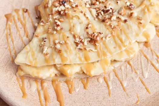 photo of delicious crepe with banana, walnuts and decorated with cajeta. sweet crepe.